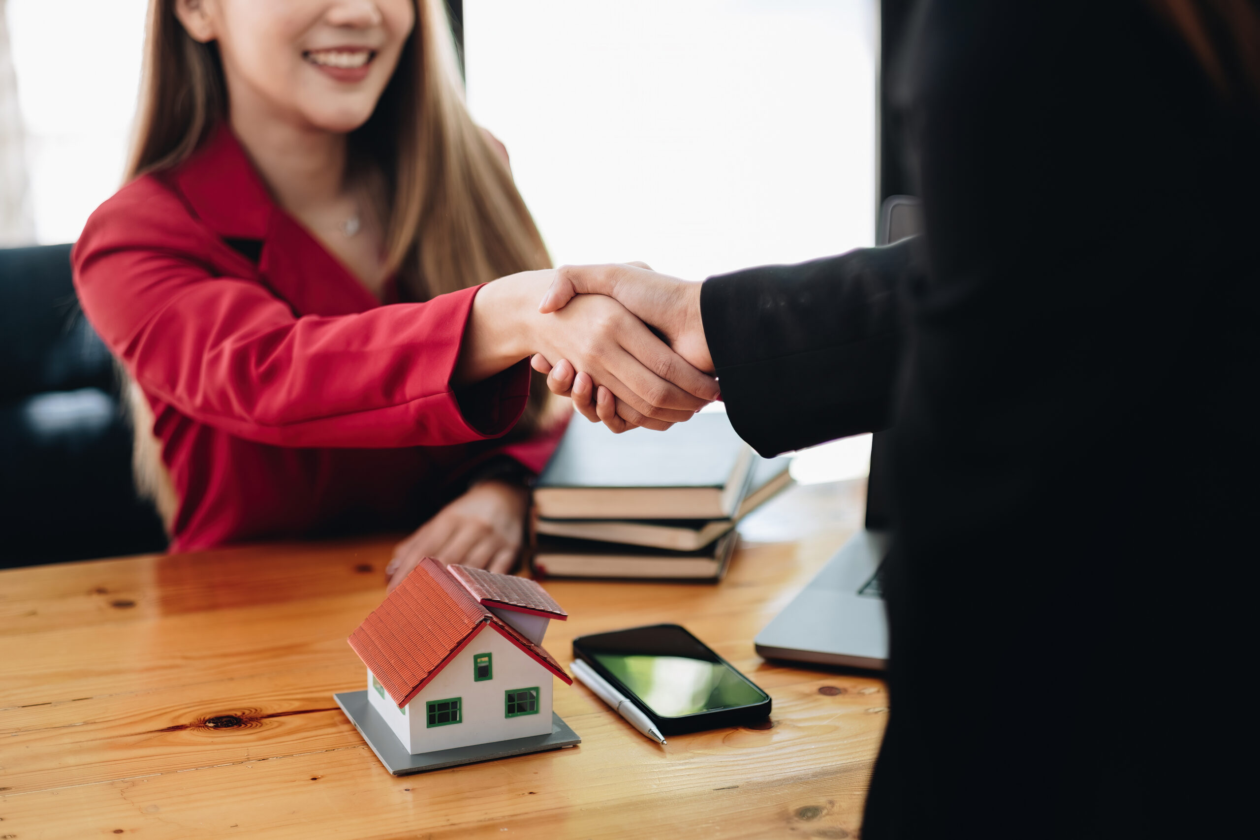 Estate agent and customer shaking hands after finished contract after about home insurance and investment loan Estate agent and customer shaking hands after finished contract after about home insurance and investment loan